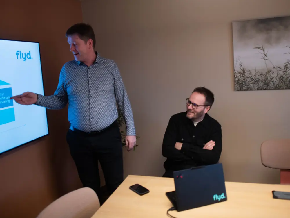 Kollega presenterer for teamet på møterommet