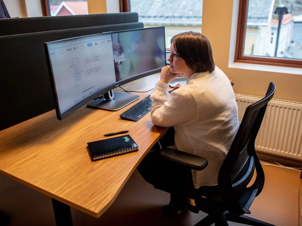 Flyd-ansatt jobber med en nettside på bred skjerm